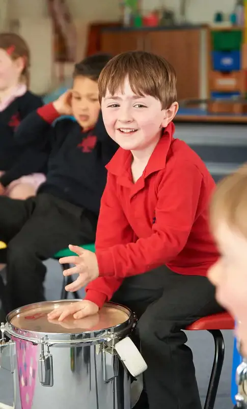 Nursery child playing the drums