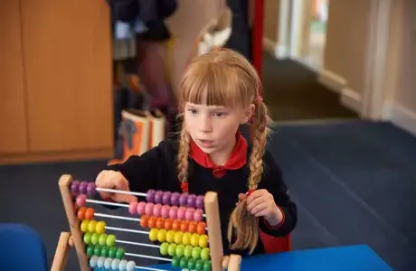 Rendcomb College pupil with abacus
