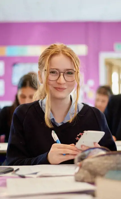 A happy senior school girl in class