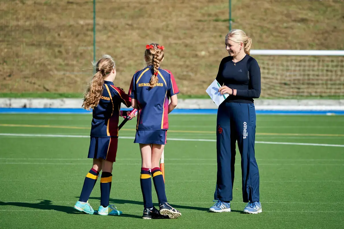 Hockey teacher with pupils at Rendcomb College, a leading private boarding school in Gloucestershire