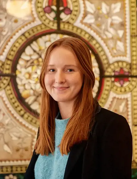 Rendcomb College student in front of a stained glass window