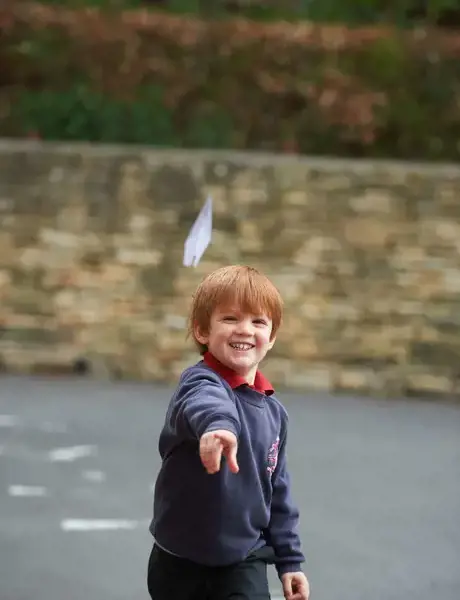 Rendcomb College pupil throwing a paper plane