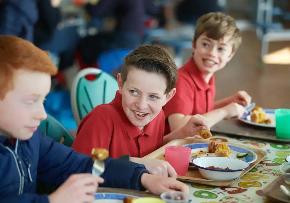 Happy boy eating lunch in the dining hall