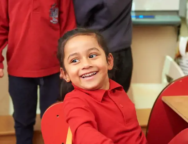 A smiling Rendcomb College Nursery pupil