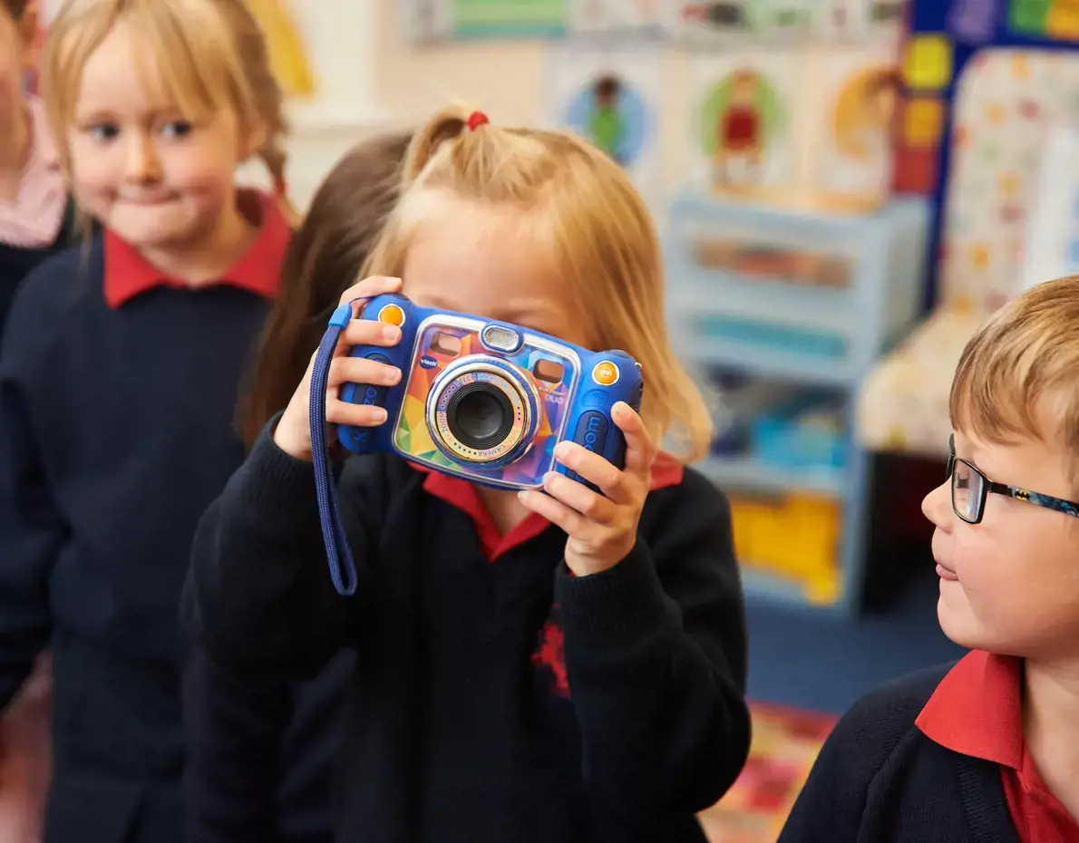 Nursery pupil playing with a toy camera