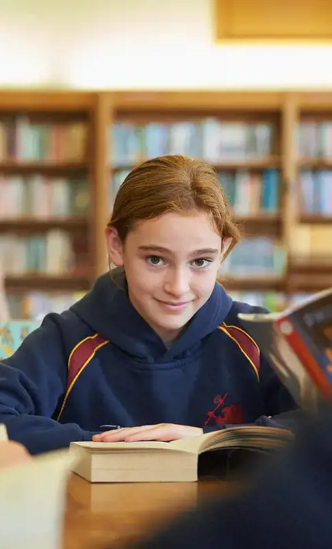 A happy pupil reading in class