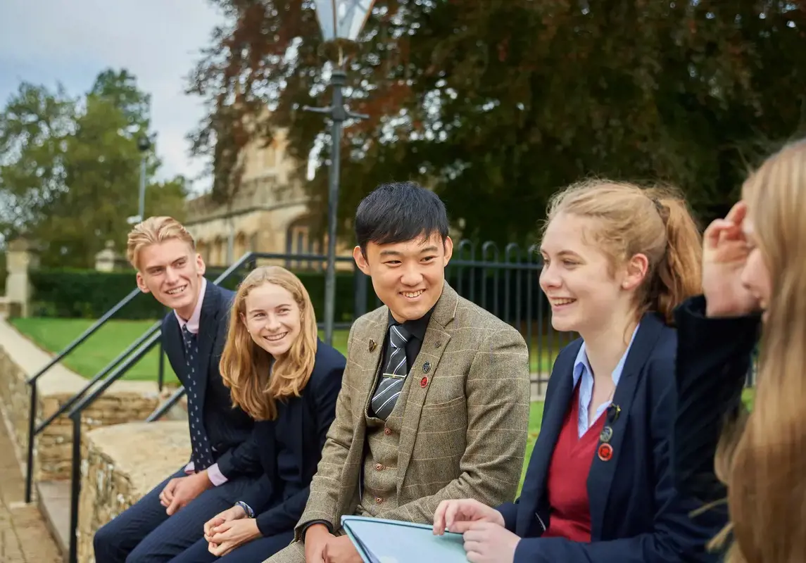 A group of happy students, relaxing and chatting in the school grounds